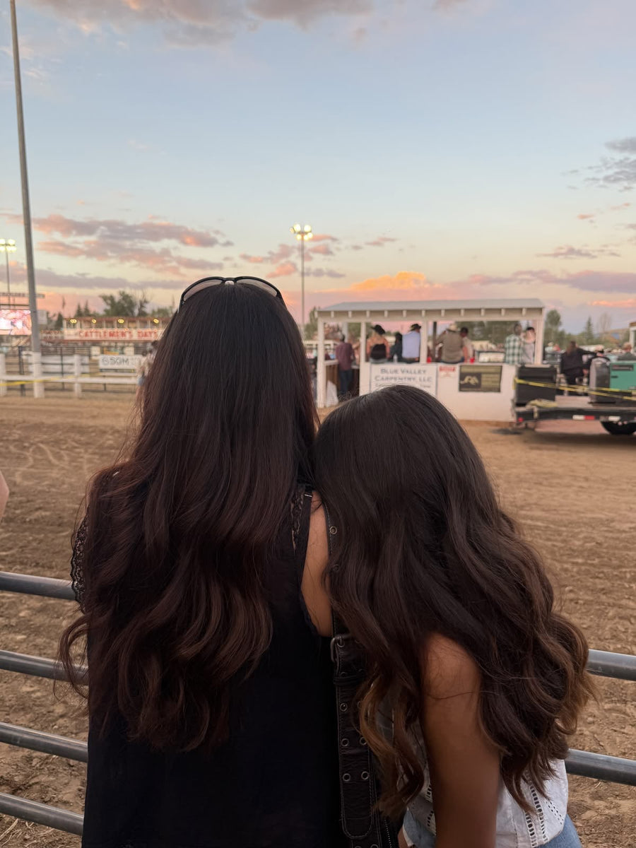 Une mère et sa fille, de dos, aux longs cheveux bruns